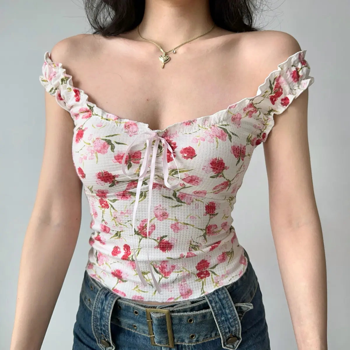 Front view of white floral cami top showing the ruffled straps, sweetheart neckline, and fitted corset-style bodice