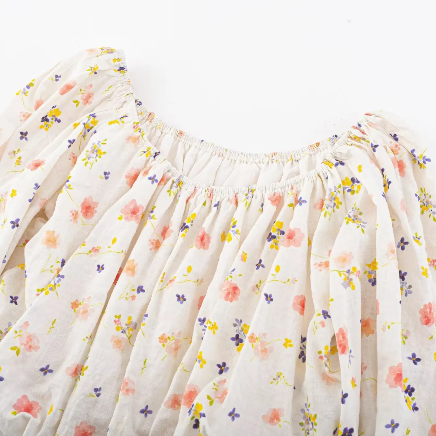 Neckline partial close-up, full elastic ruched boat neck, scattered pink yellow purple floral print textured woven fabric