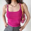 Outfit view of fuchsia cami top styled with gray trousers, highlighting the stretchy ribbed fabric