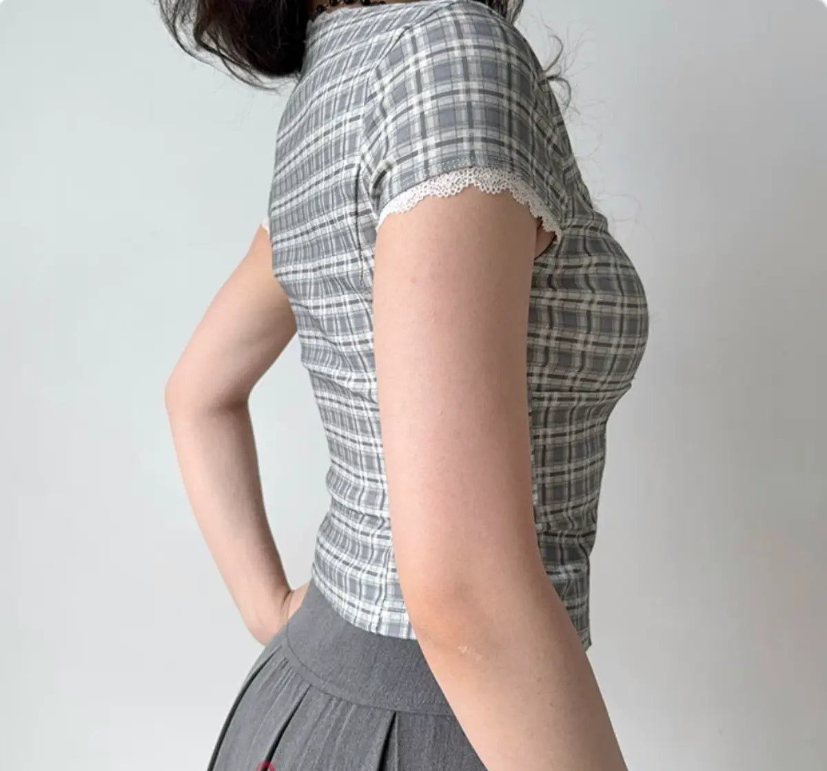 Back view of gray plaid top showing the fitted waist and cap sleeve detail