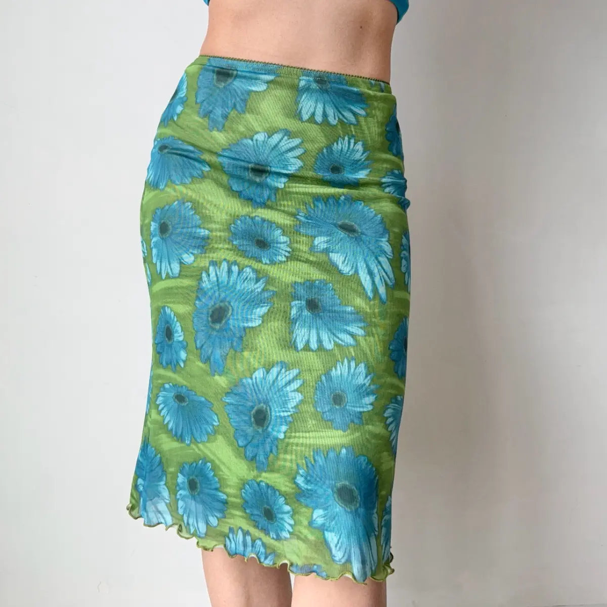 Side view of green floral midi skirt with blue top