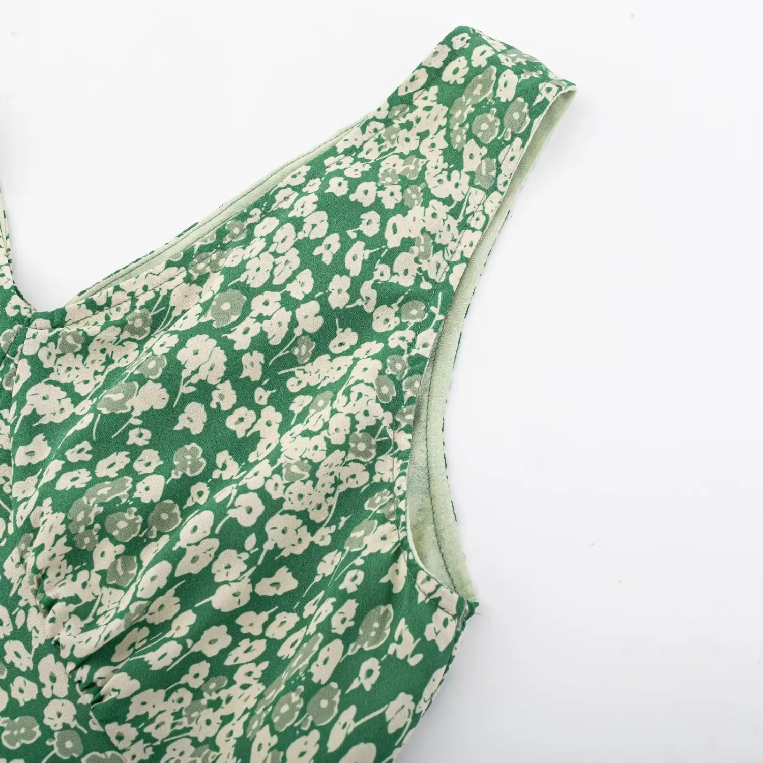 Sleeveless shoulder strap close-up of green floral dress, matched green lining and neat edge stitching