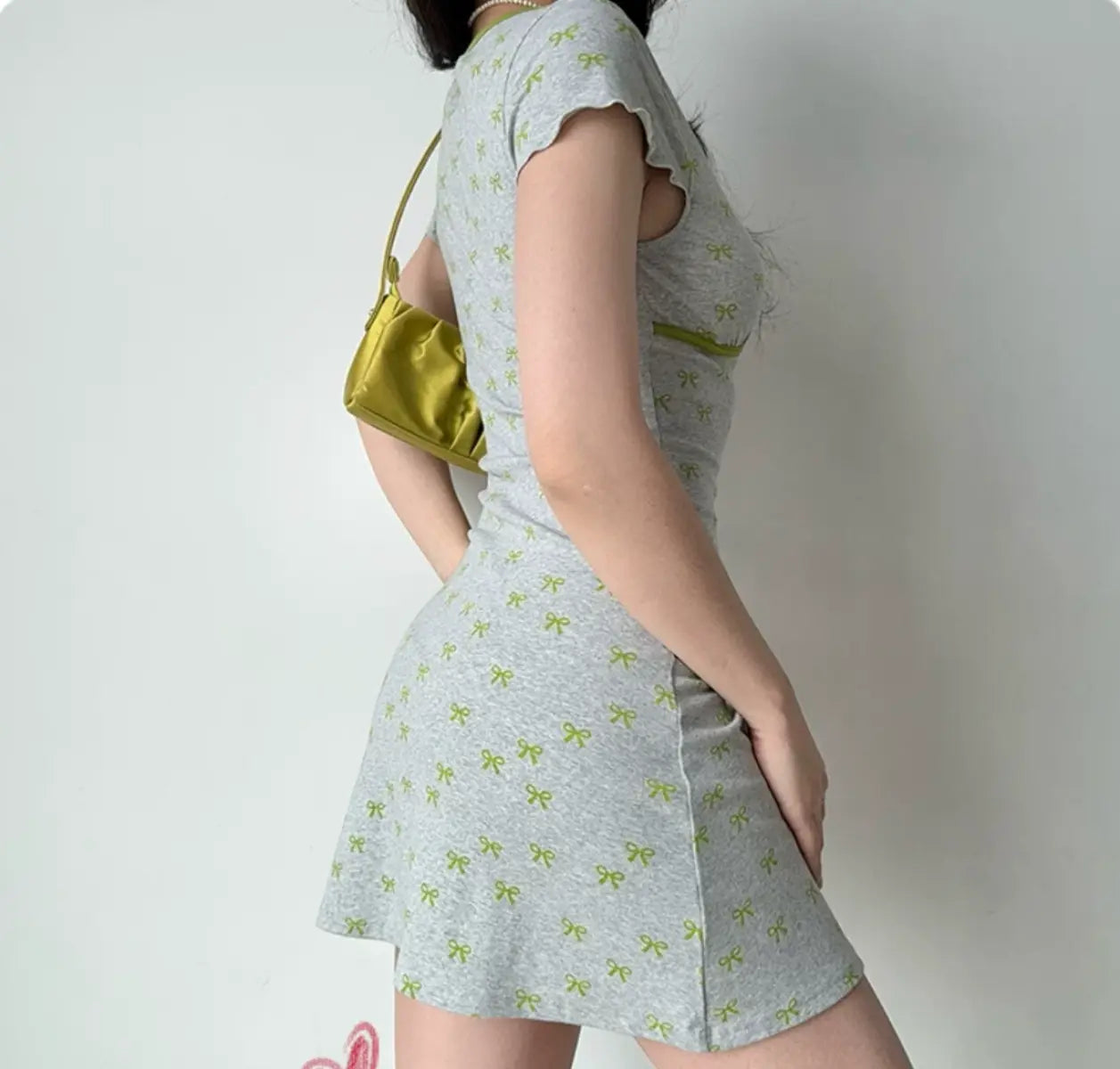 Back view of grey knit dress with green bow print