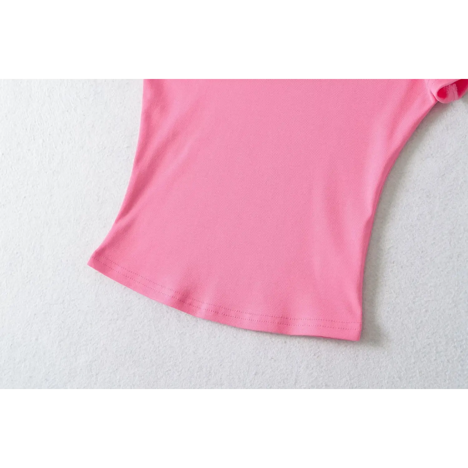 Waist hem curved cut close-up of hot pink stretch ribbed fitted short sleeve tee