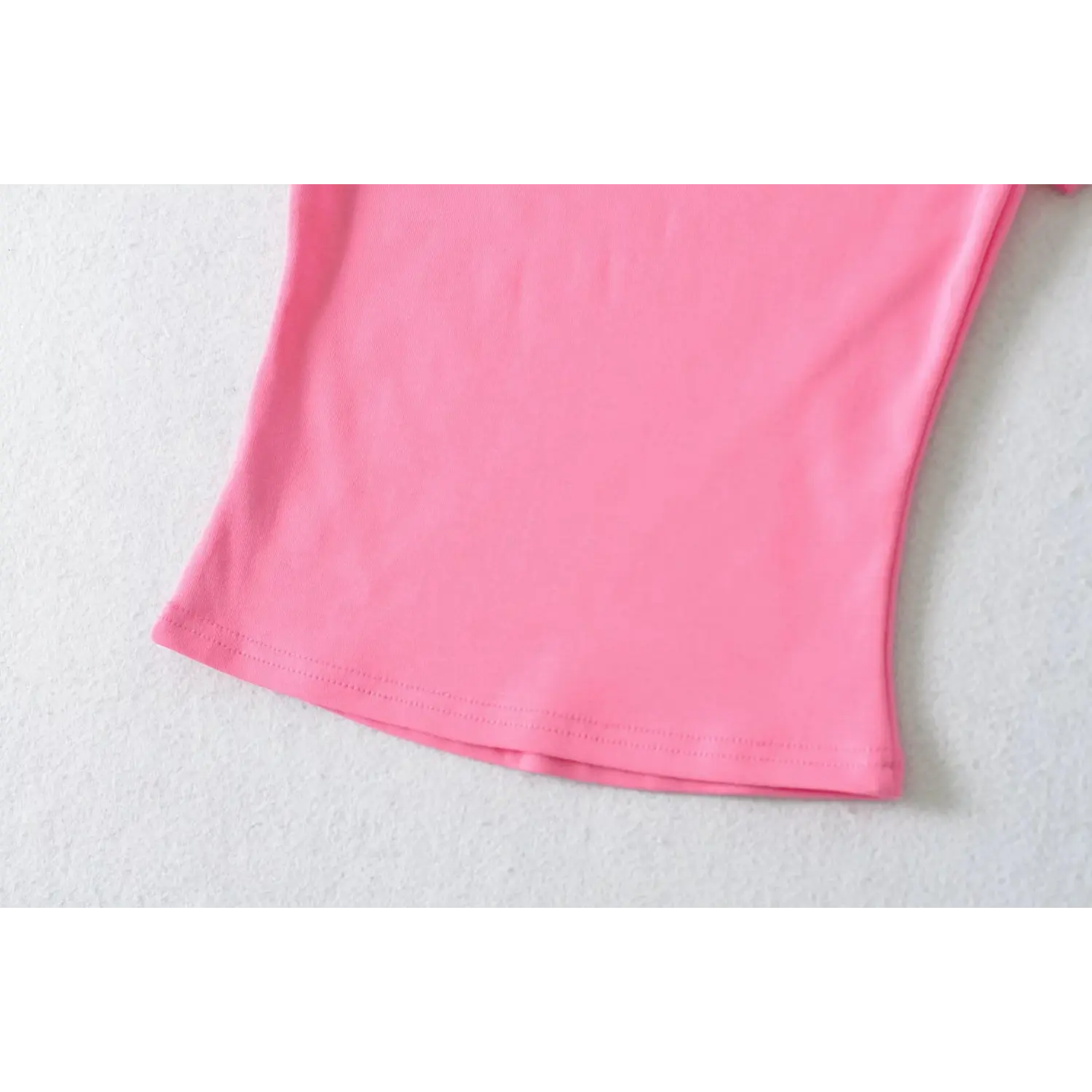 Curved waist hem double row stitching close-up of hot pink stretch ribbed slim short sleeve tee