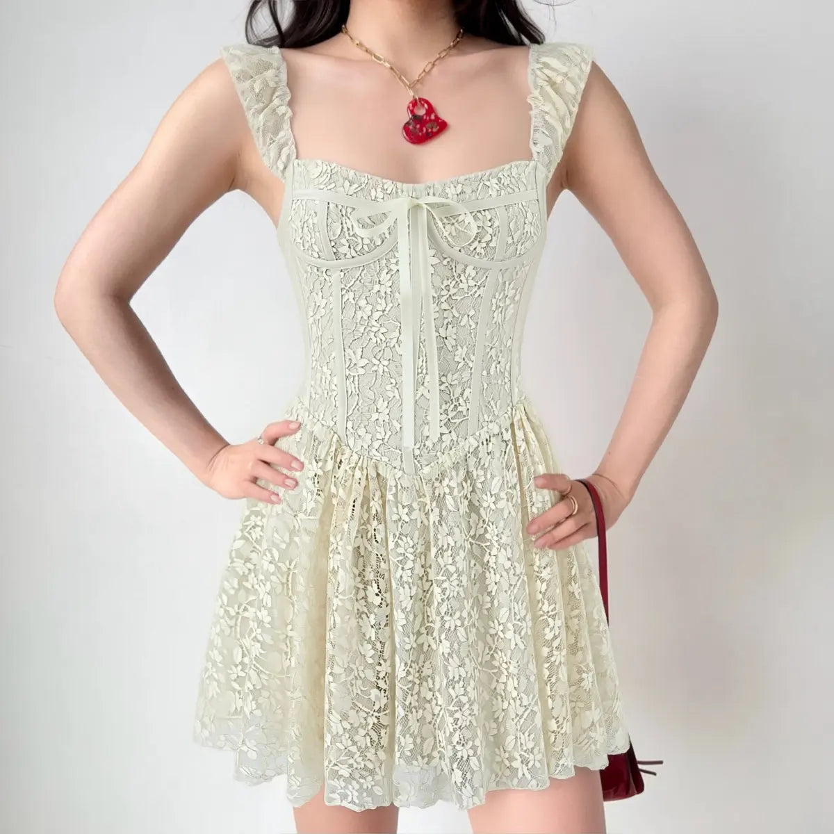 Model wearing ivory lace cami mini dress, front view