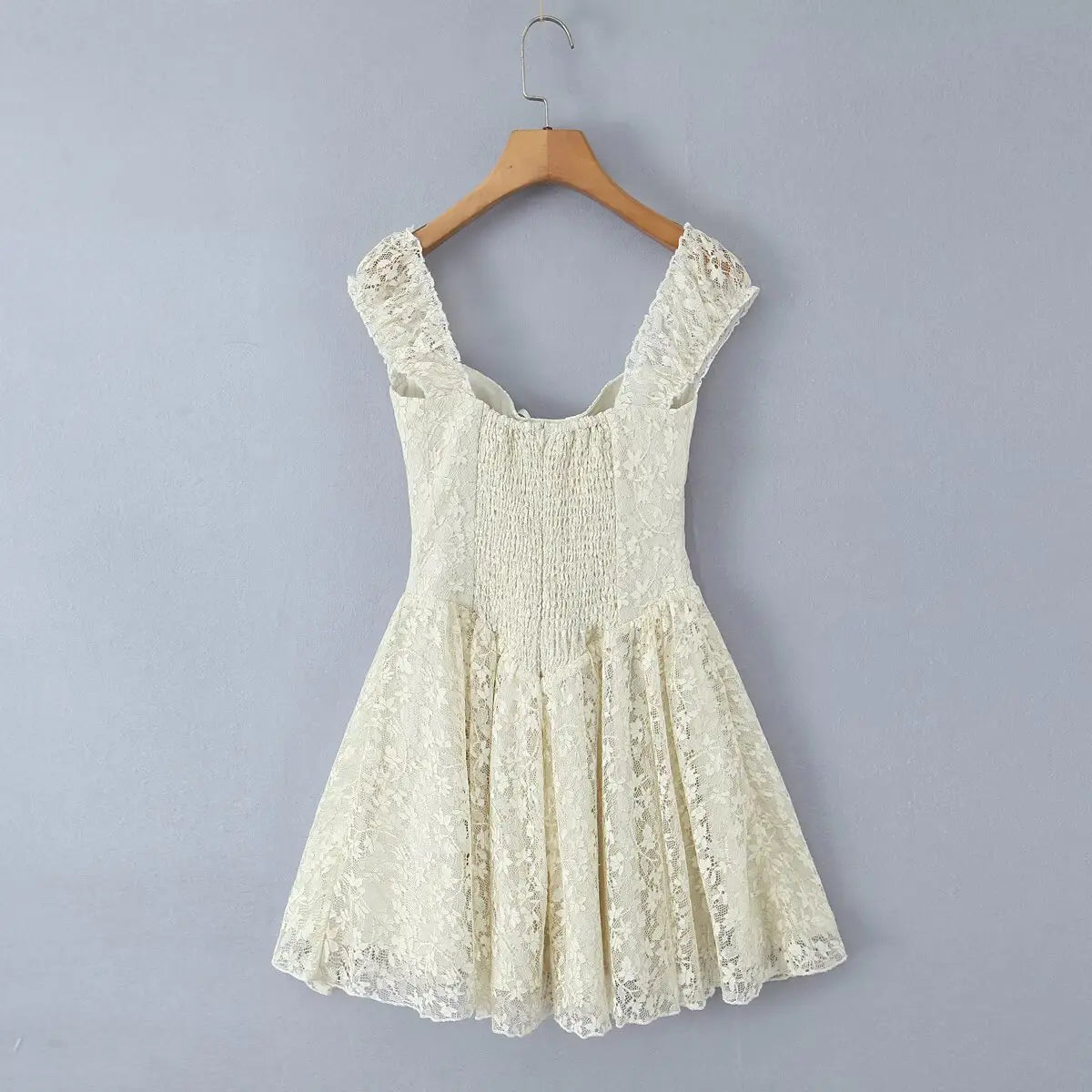 Ivory lace cami mini dress hanging on wooden hanger, back view