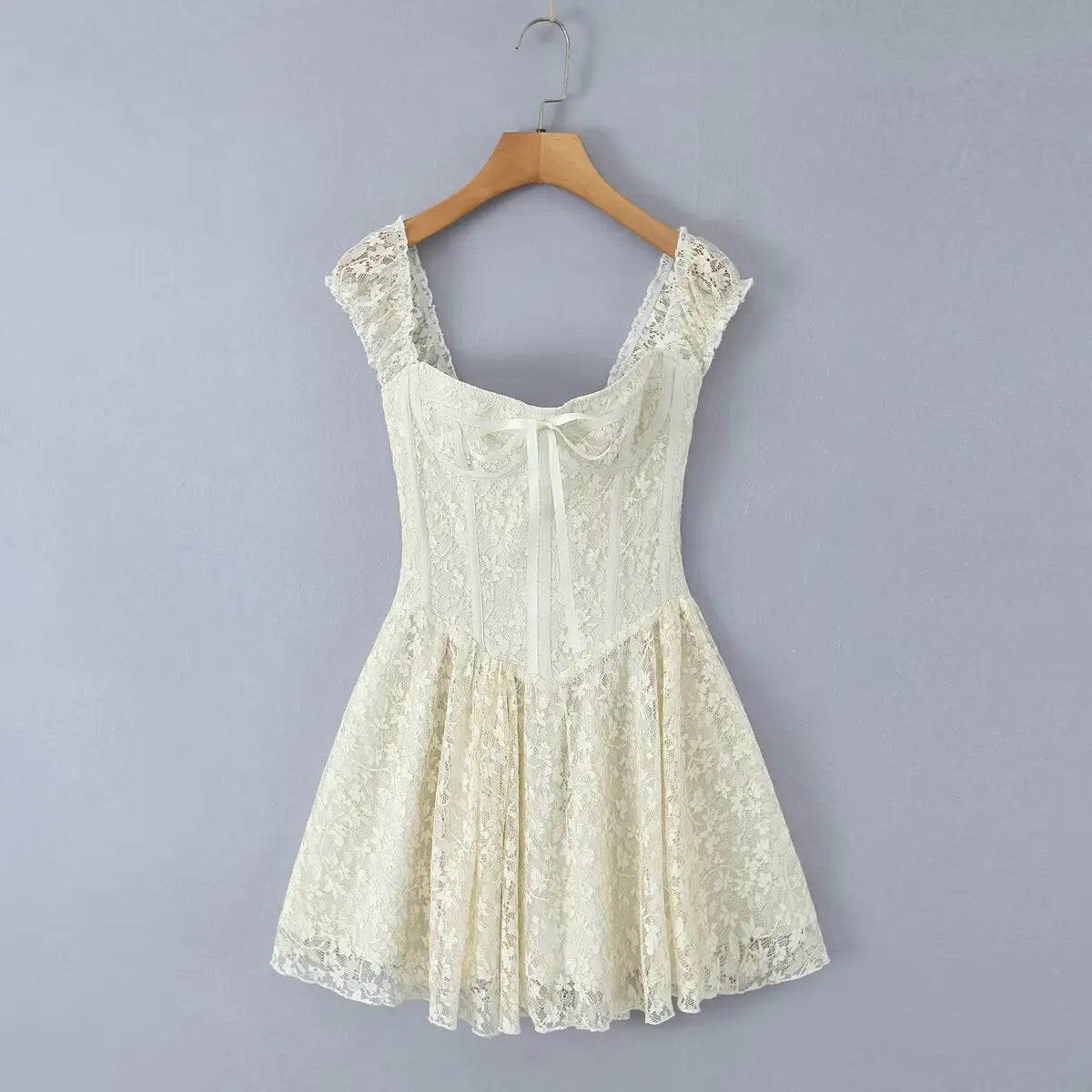 Ivory lace cami mini dress hanging on wooden hanger, front view