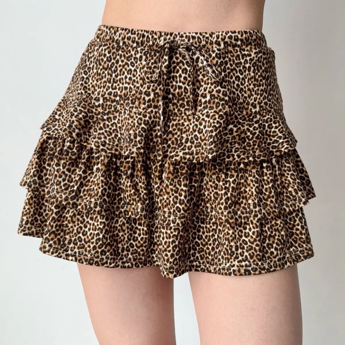 Model wearing leopard print ruffled mini skirt, front view