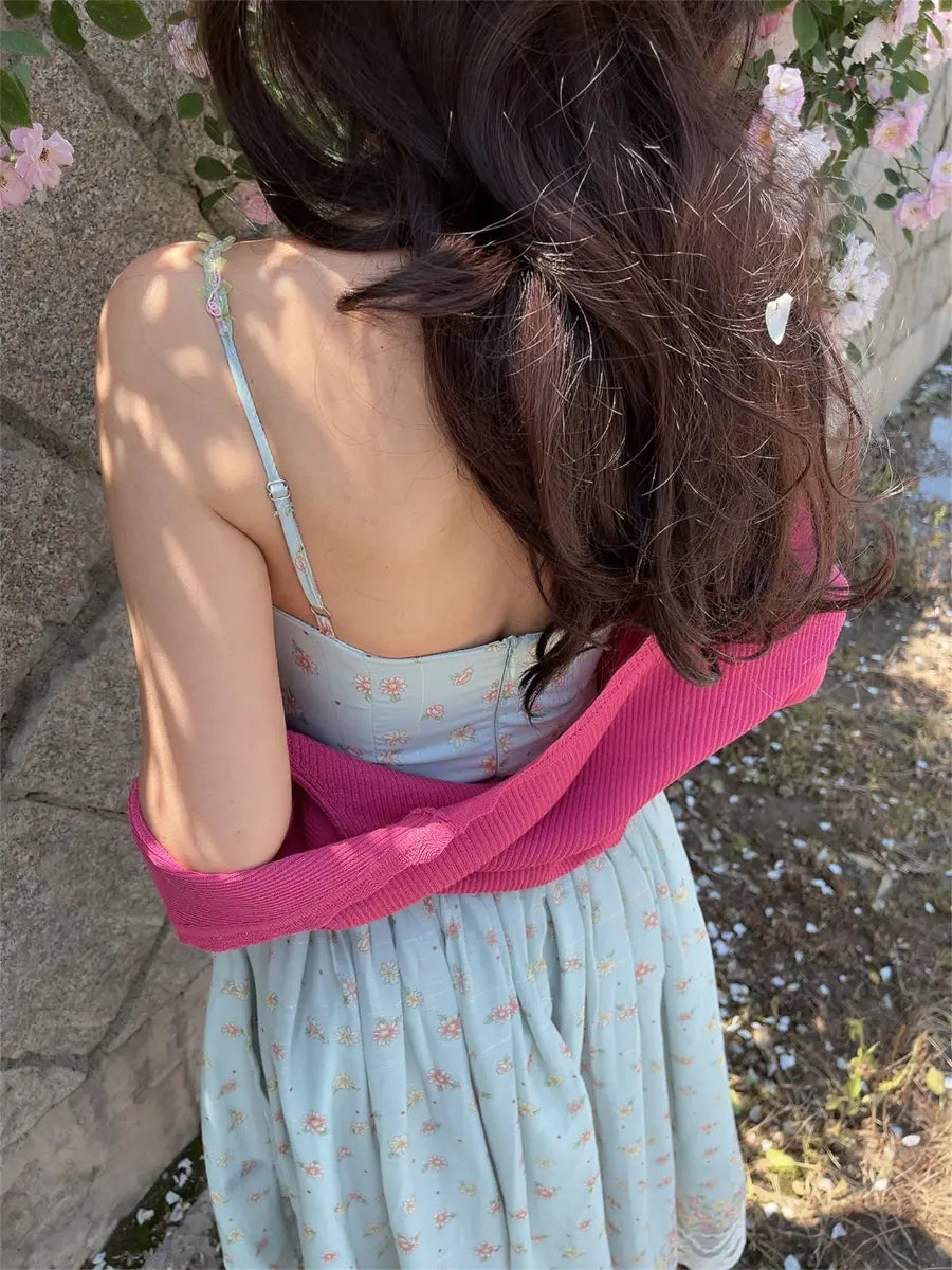 Back view of light blue floral cami dress showing the fitted waist, spaghetti straps, and flowy tiered skirt hem