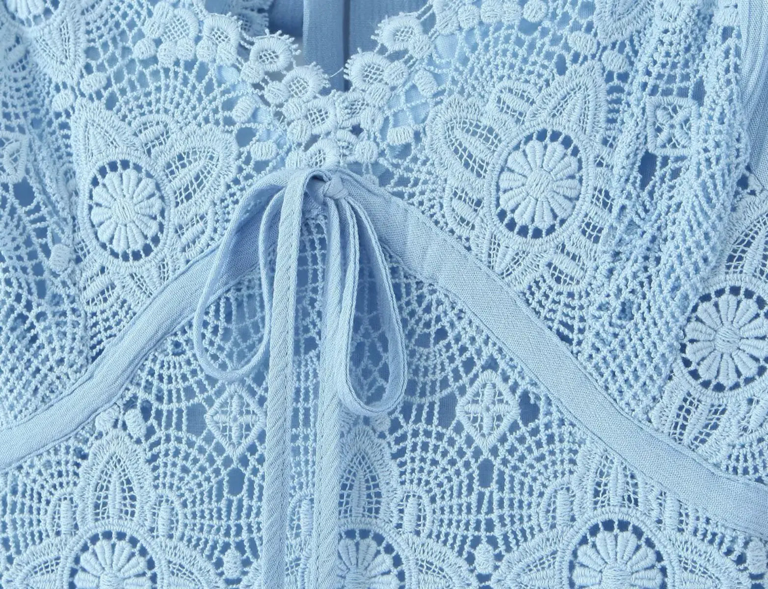 Detailed view of floral lace pattern and tie detail on light blue maxi dress
