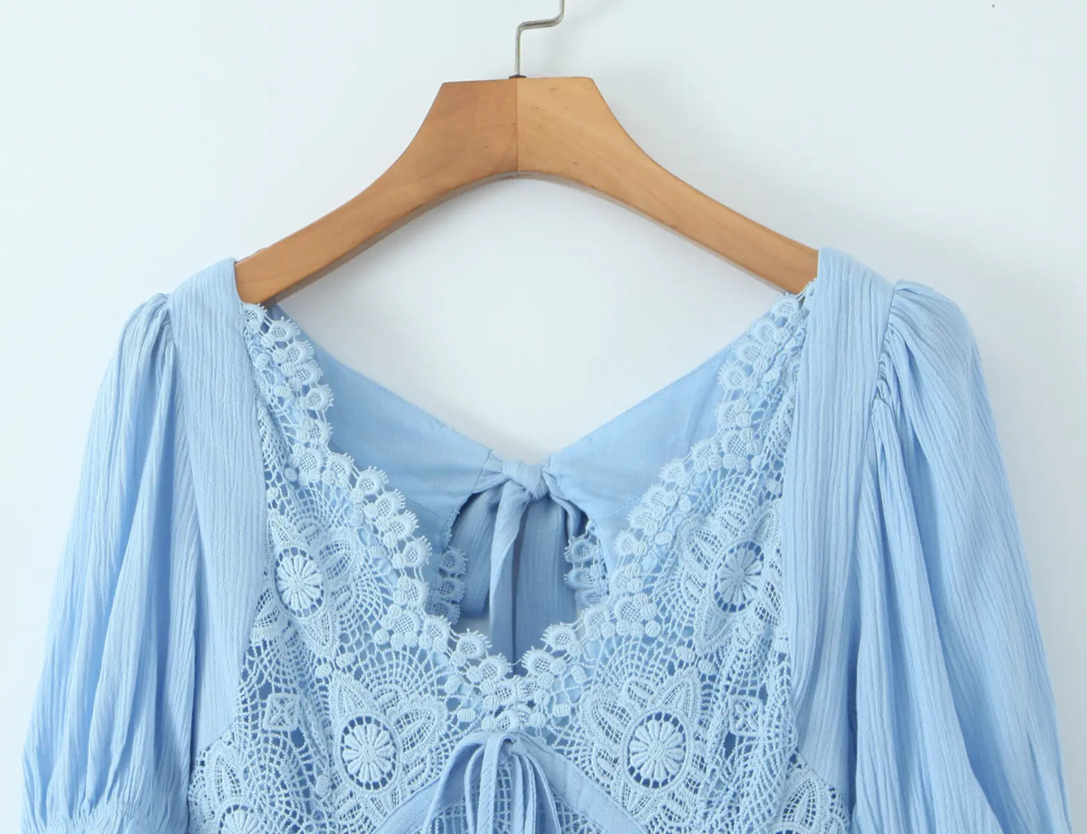 Close-up of lace-trim V-neckline and puff sleeves on light blue maxi dress
