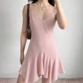 Model wearing light pink V-neck slip dress with thin straps and asymmetric hem