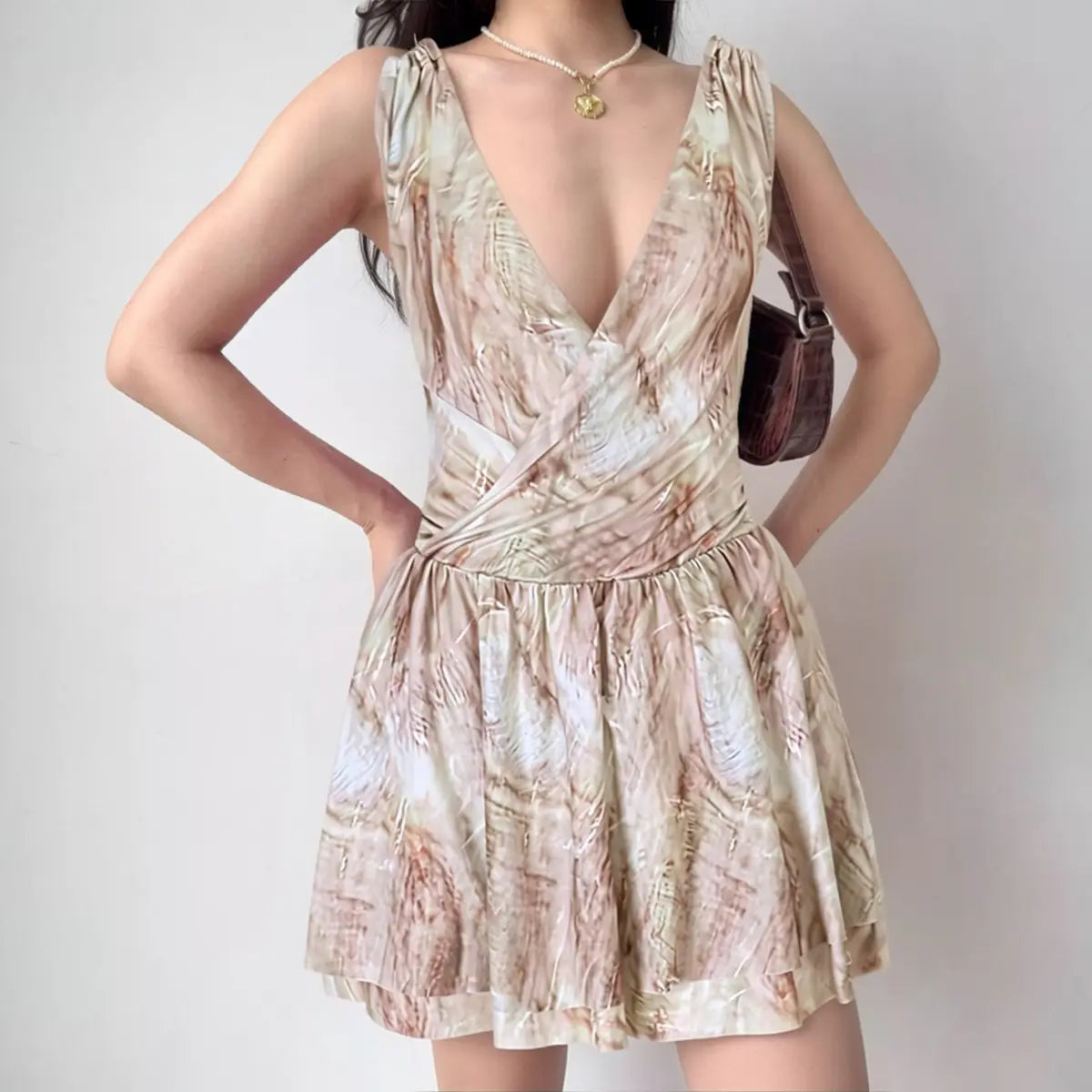 Model wearing marble-print dress with deep V-neck and tiered ruffle hem, flowy wrap-style party dress