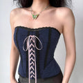 Model wearing navy blue lace-trim corset top with pink lace-up front, vintage-inspired strapless bustier