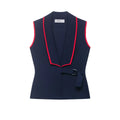 Front view of navy knit vest with red contrast piping, wrap design and buckle belt detail