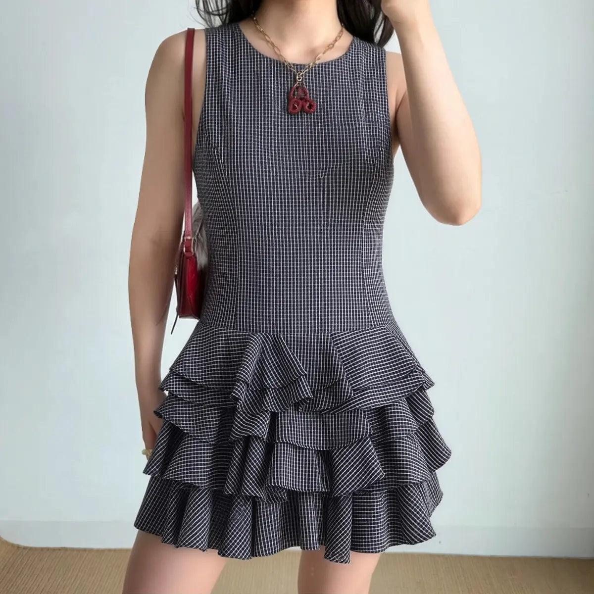 Model in navy plaid tiered ruffle mini dress