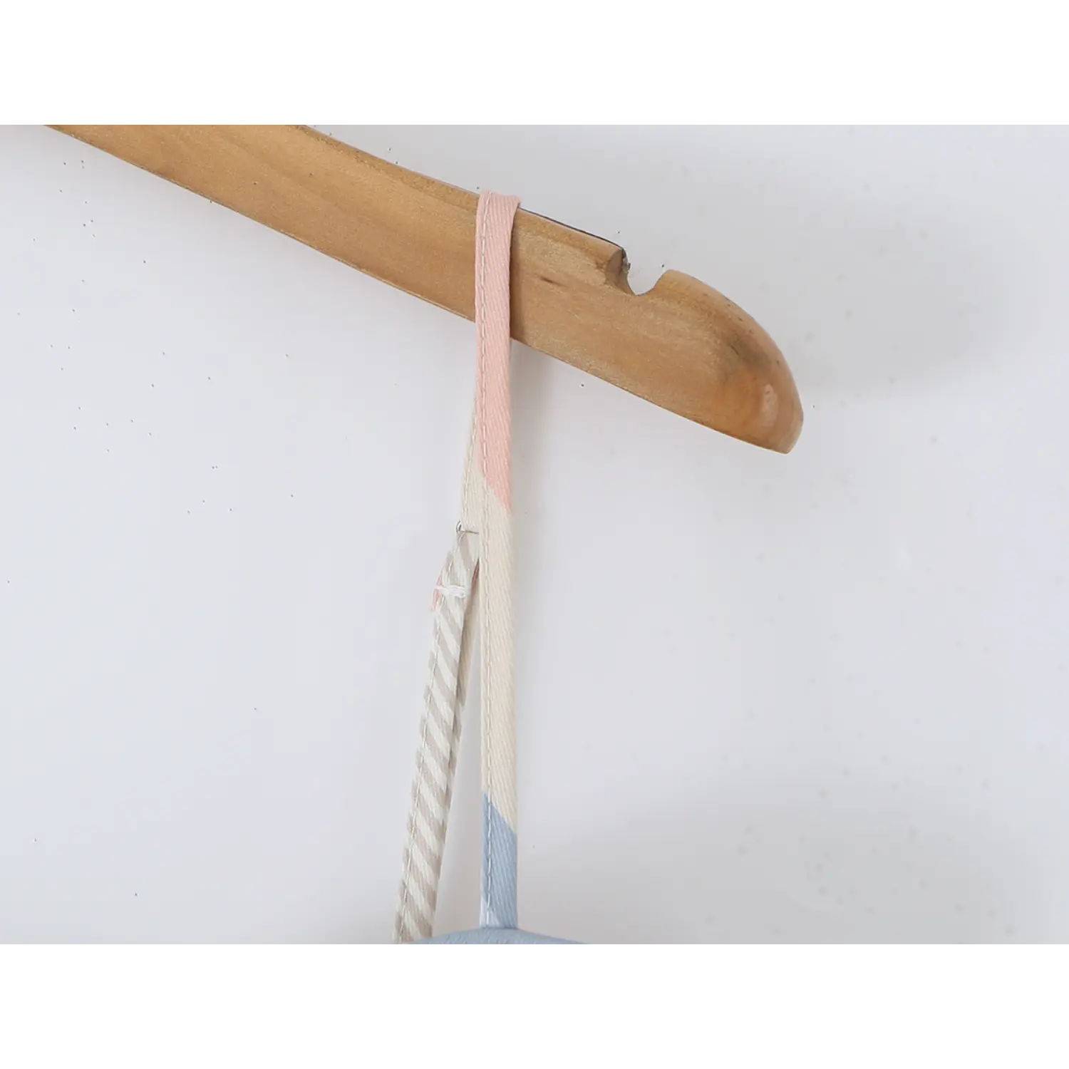 Close-up of matching striped spaghetti strap with silver metal slider adjuster, clean edge topstitching