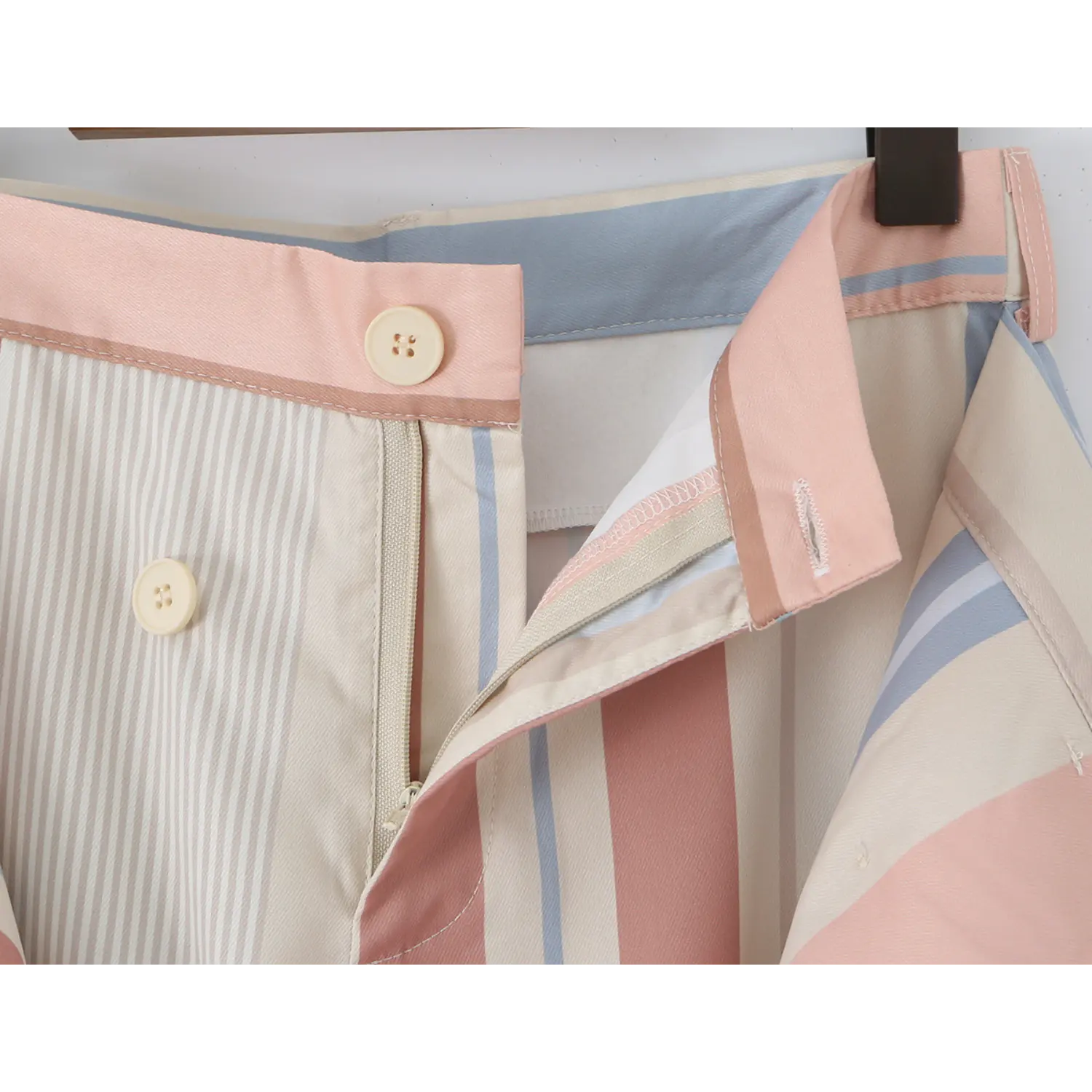Close-up of inner waist fly, matching cream four-hole button, vertical invisible zipper and full white inner lining