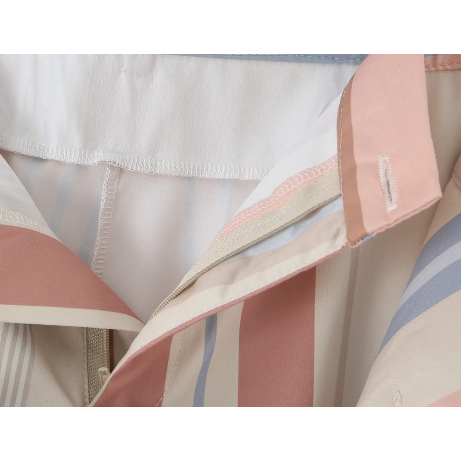 Macro shot of inner waist lining neat serged edge stitching, soft lightweight striped twill fabric