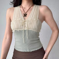 Model wearing off-white halter-neck top with pleated lace-up front and ribbed knit bottom, two-tone cropped cami