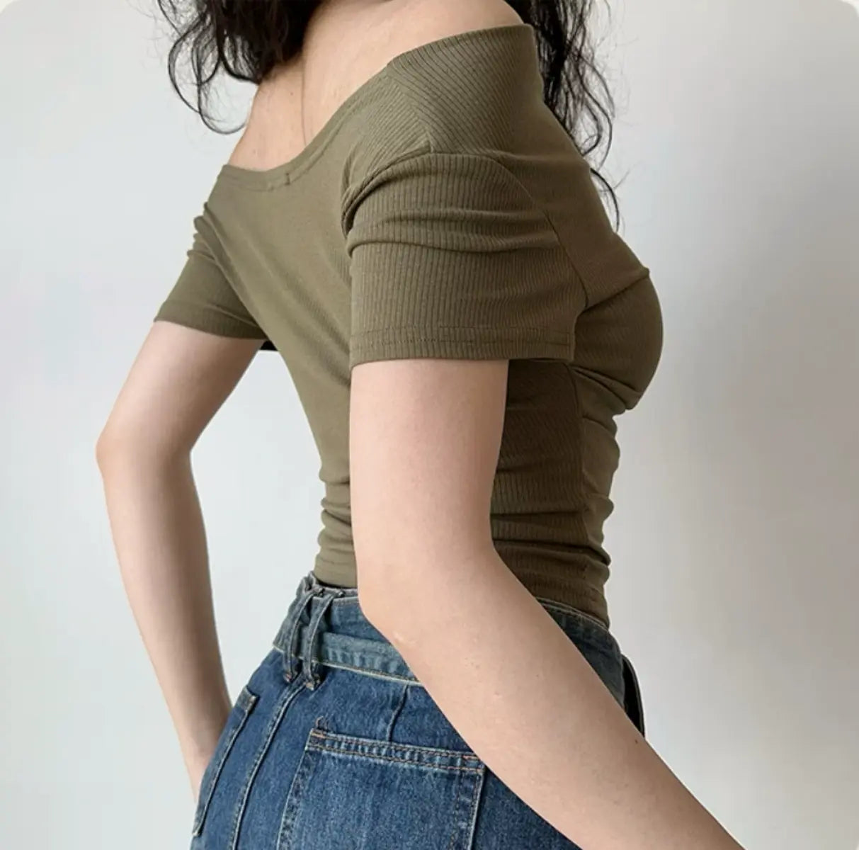 Back view of olive green ribbed off-the-shoulder top with short sleeves and fitted waist