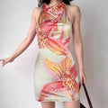 Model wearing orchid-print satin halter-neck dress with cowl neck, form-fitting mini slip dress