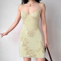 Model wearing pale yellow 3D floral applique spaghetti-strap mini dress, elegant feminine party dress