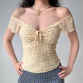 Outfit view of pale yellow floral mesh top styled with denim shorts