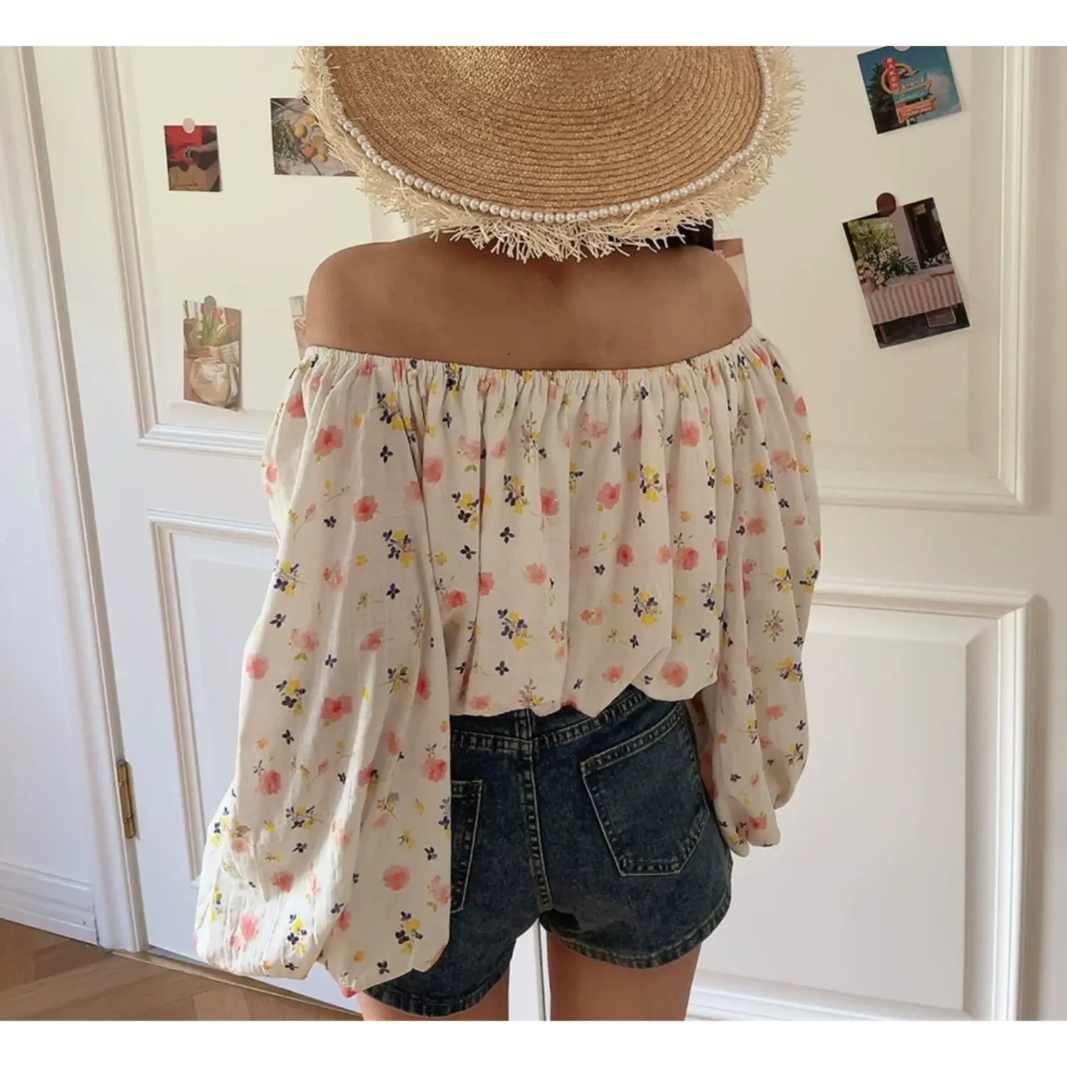 Complete back lifestyle shot of floral off shoulder blouse, full elastic neckline, loose balloon long sleeves, soft textured woven fabric