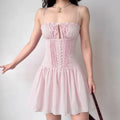 Model wearing pink bow-front corset-style mini dress with button detail, romantic feminine party dress