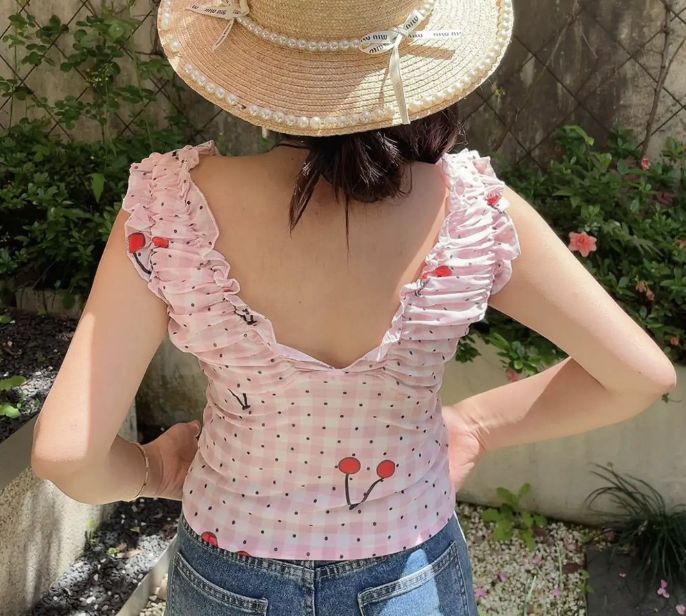 Back view of pink cherry print off-shoulder top with V-shaped back and fitted silhouette