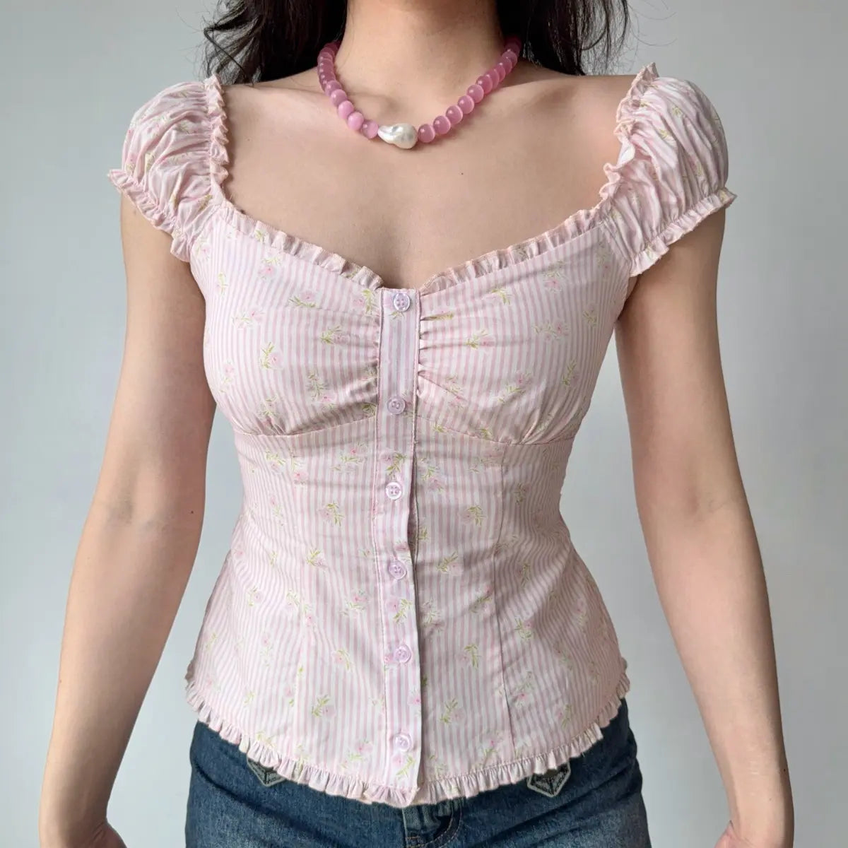 Front view of pink floral gingham top with ruffled sweetheart neckline and gathered bust