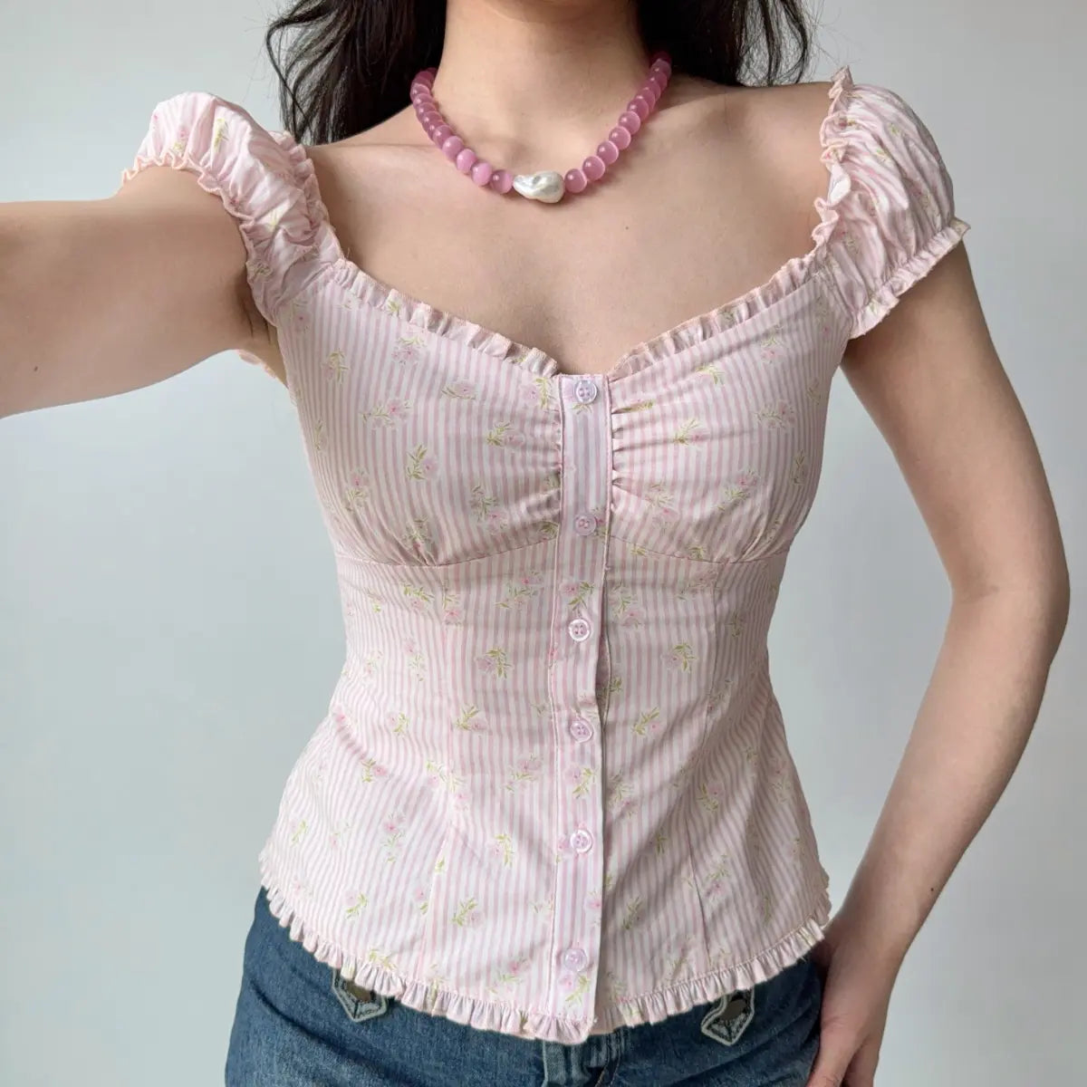 Outfit view of pink floral gingham top styled with denim jeans