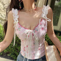 Front view of pink floral lace camisole top on model
