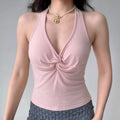 Model wearing pink halter-neck cami top with twist-front detail, bodycon cropped tank