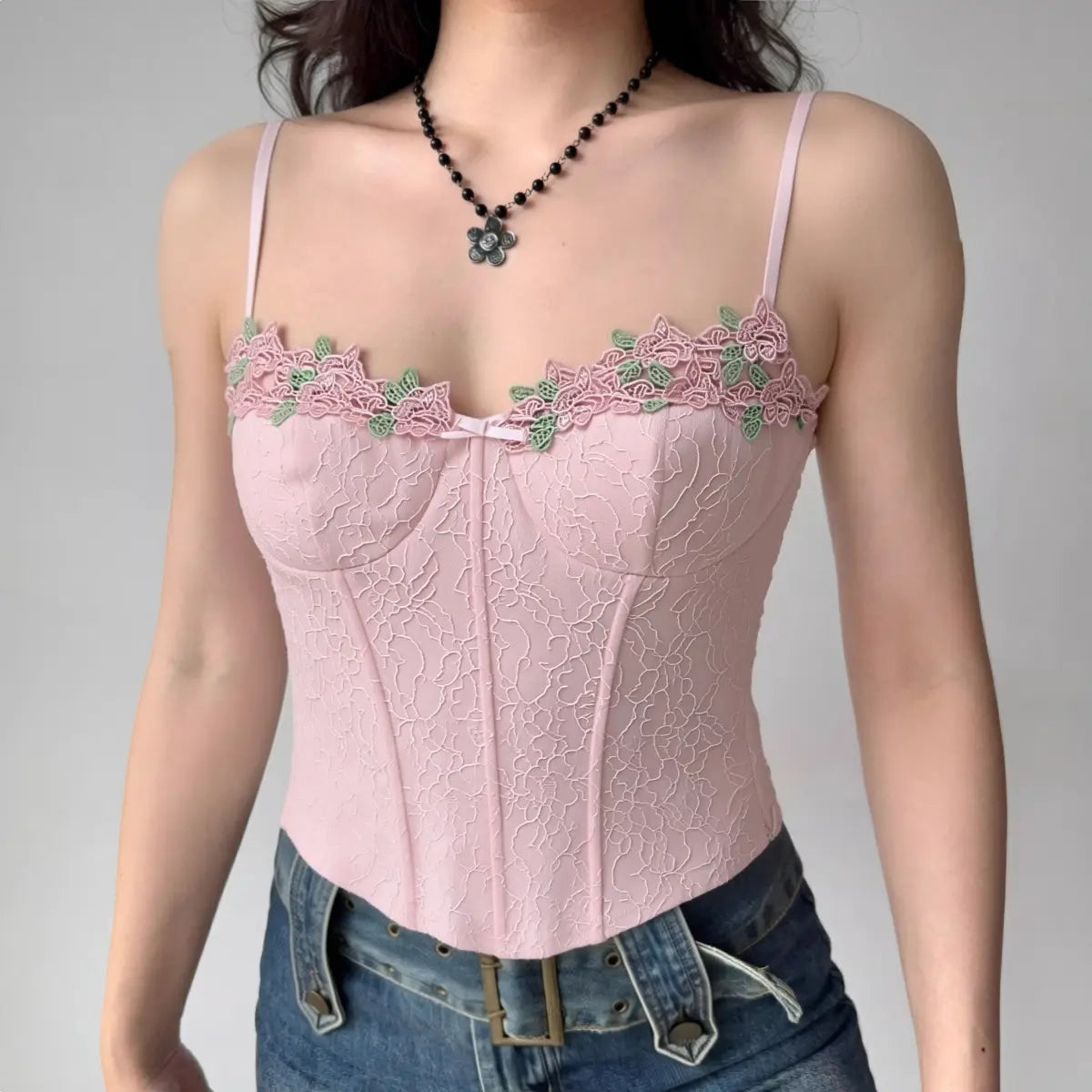 Model wearing pink lace cami top with floral embroidery and sweetheart neckline, bustier-style spaghetti-strap top
