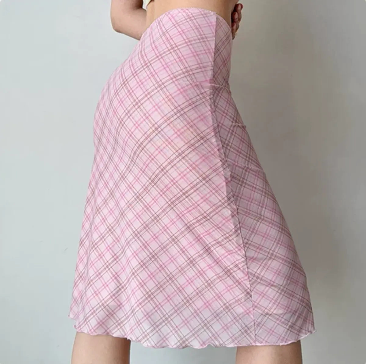 Model wearing pink plaid mesh midi skirt, side view