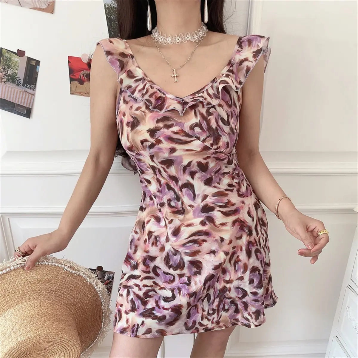 Model wearing pink purple leopard print mini dress with ruffled straps and V-neckline