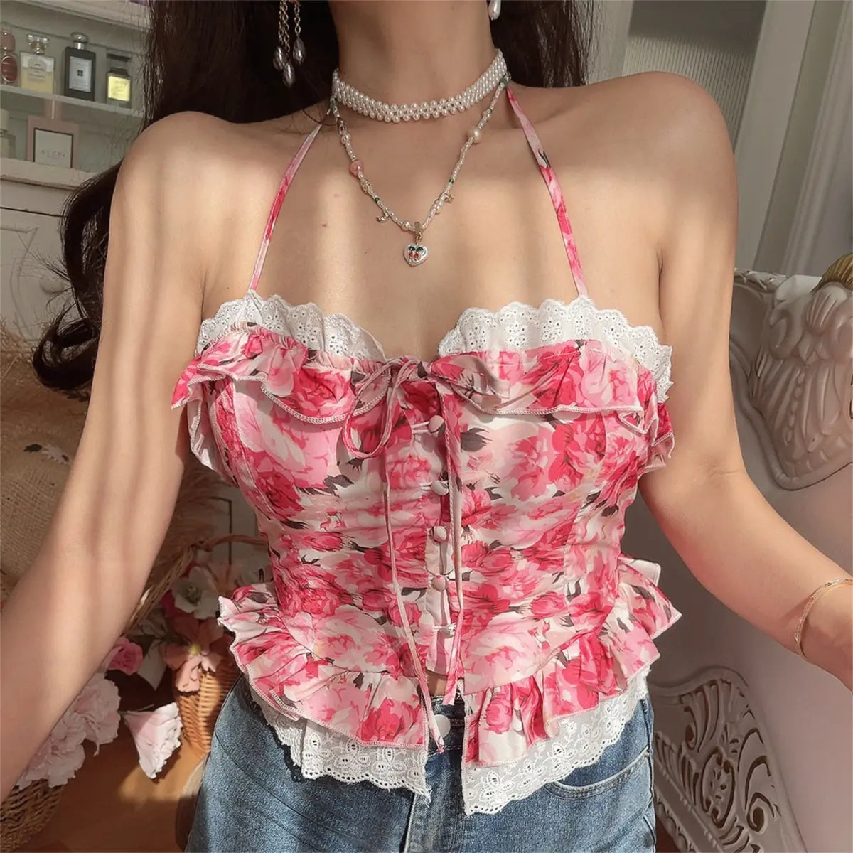 Close-up front view of model wearing pink rose print halter cami top