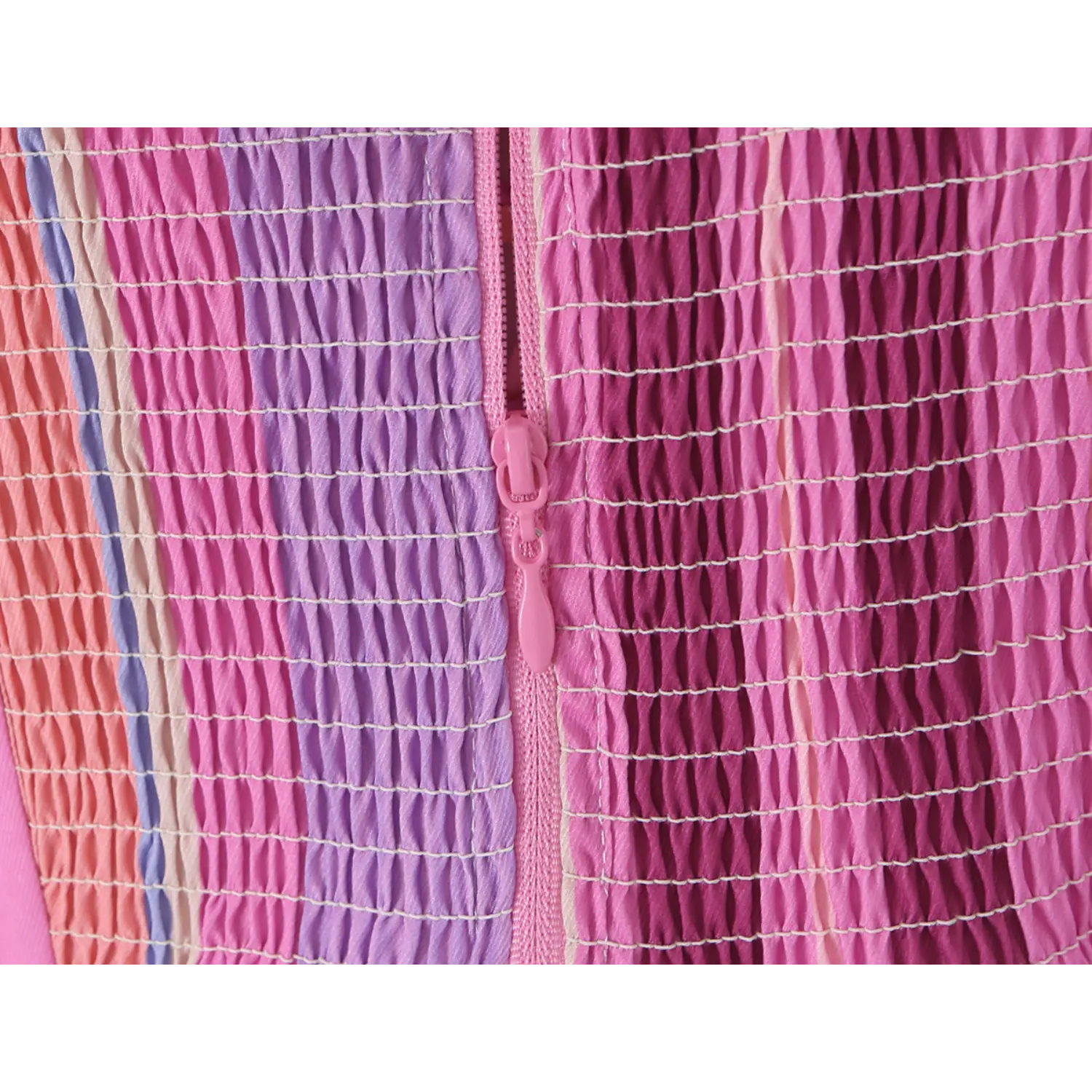 Close-up of matching pink plastic invisible zipper set within wide elastic smocked back fabric