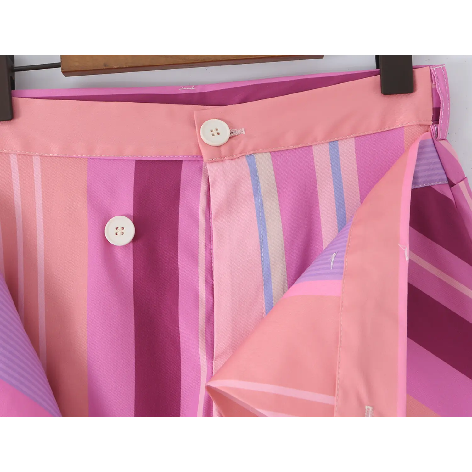 Close-up of front waist dual four-hole white buttons, inner fly invisible zipper and layered wrap waist construction