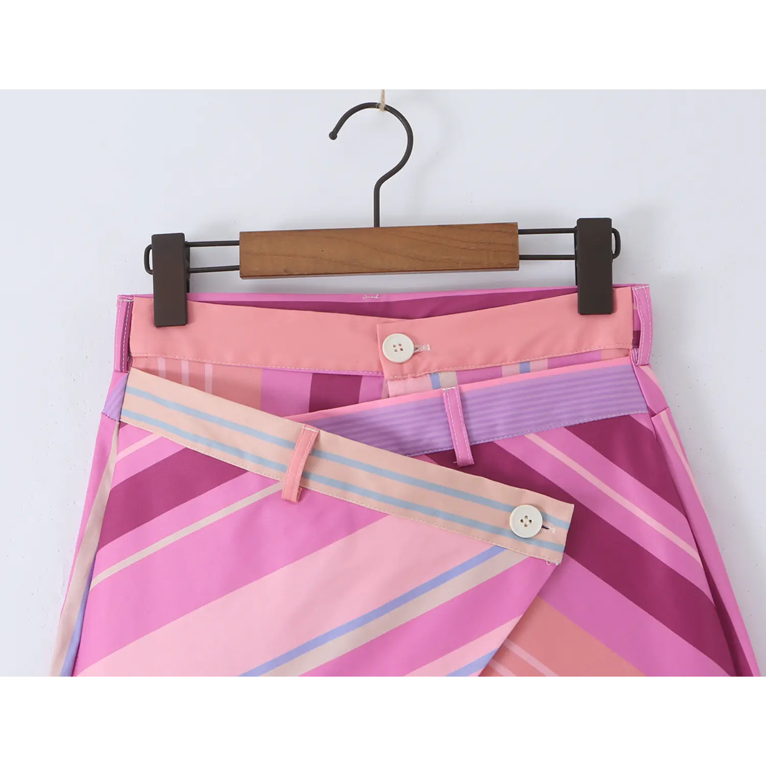 Close-up of dual waistband design, cross wrap diagonal flap with four-hole white matching button and fabric belt loops