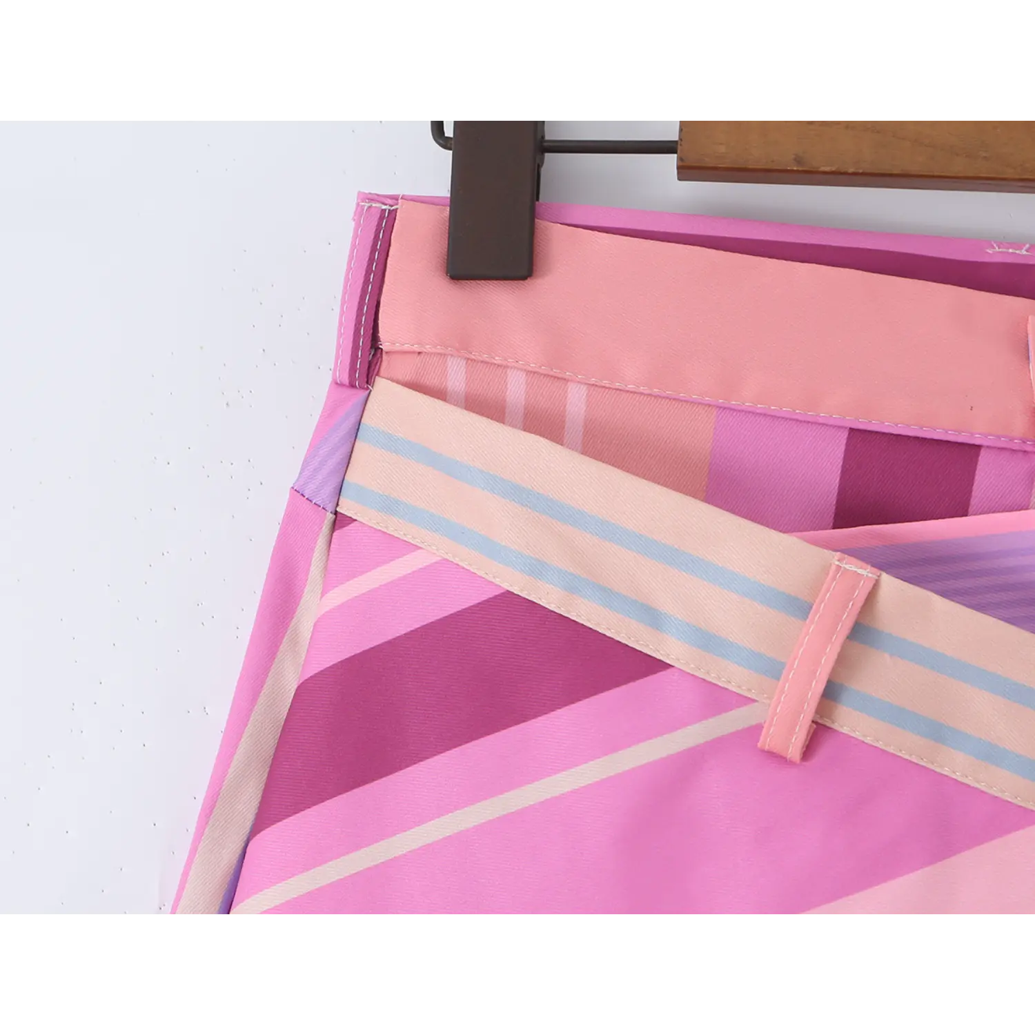 Waistband fabric belt loop close-up, dual-layer waist construction with mixed pink purple vertical stripe print