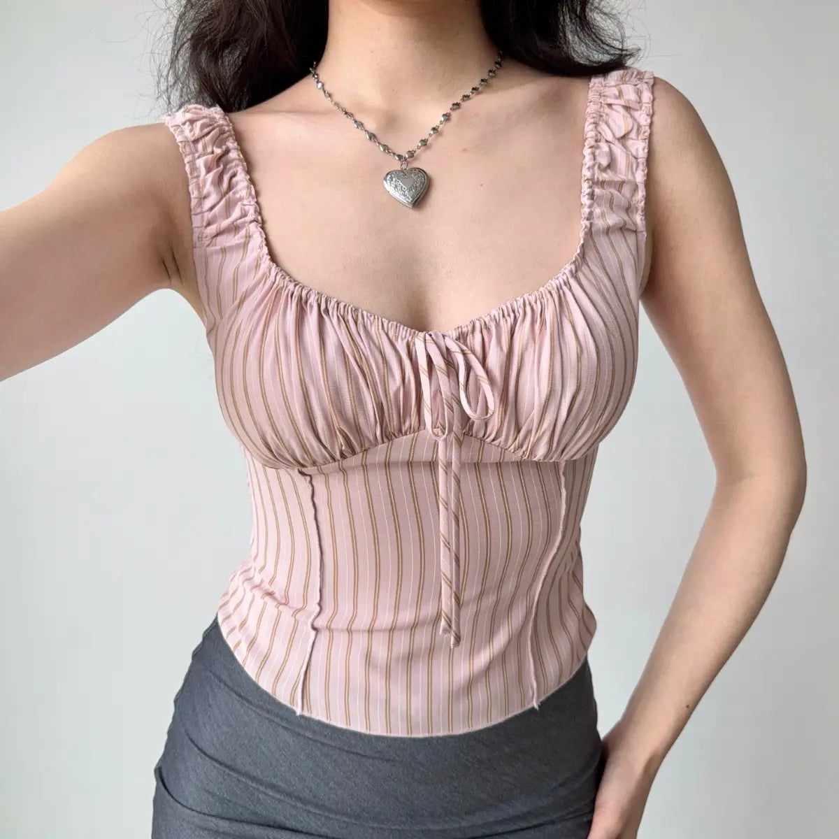 Front view of pink striped cami top showing the ruched bust and front tie detail