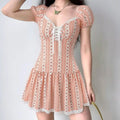 Model wearing pink white ditsy floral puff-sleeve corset mini dress with lace-up front, feminine cottagecore outfit