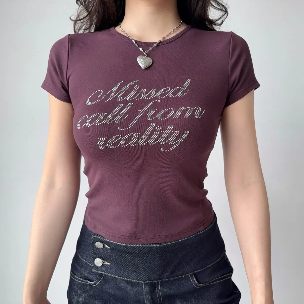 Outfit view of plum t-shirt styled with dark denim jeans, highlighting the stretchy fabric