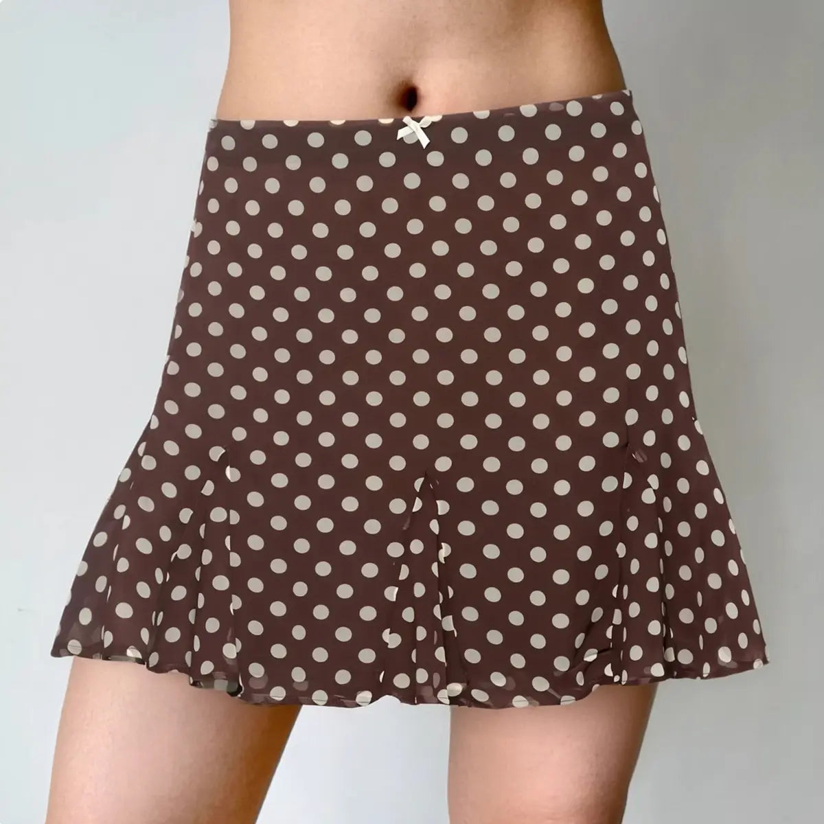 Model wearing brown white polka dot flounce mini skirt with ruffled hem