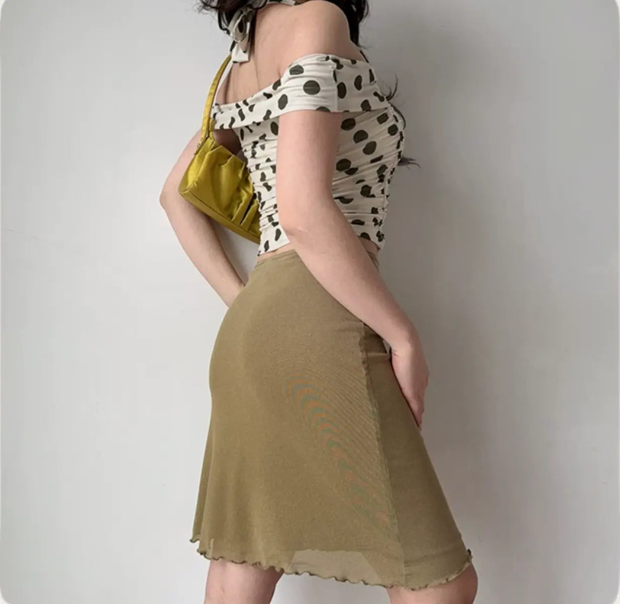 Model in polka dot halter top, back-side view