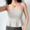 Model wearing white black polka dot peplum bandeau tube top